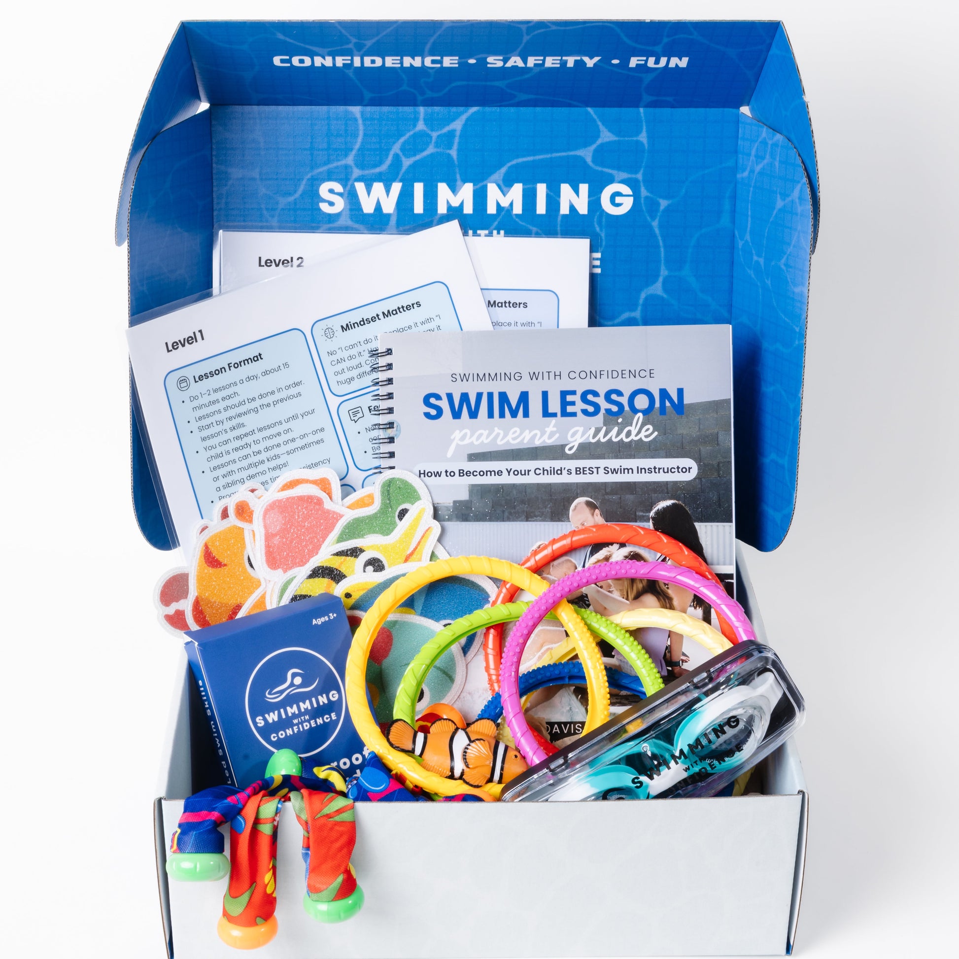 Open box containing swimming lesson materials including colorful rings and a lesson guide.