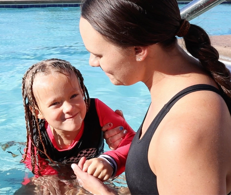 girl and swim teacher in the water 